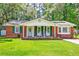 Classic brick home featuring vibrant green shutters and a welcoming front porch at 403 Forest Cir, Summerville, SC 29483