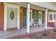 Inviting front porch with rocking chairs, brick accents, and a decorative front door with glass accents at 403 Forest Cir, Summerville, SC 29483