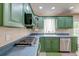 Galley kitchen features gas range, stainless steel appliances, and stylish green cabinetry at 403 Forest Cir, Summerville, SC 29483