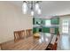 Open eat-in kitchen with green cabinetry, stainless appliances, and wood dining table at 403 Forest Cir, Summerville, SC 29483