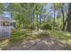 Lush backyard with mature trees, green grass, and a white chair set offer serene outdoor living at 418 Lakeview Dr, Summerville, SC 29485