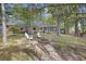 Spacious backyard featuring a firepit, Adirondack chairs, and views of the home and surrounding trees at 418 Lakeview Dr, Summerville, SC 29485