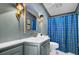 Bathroom with tiled vanity, gold sconces, plaid shower curtain, and custom mirror at 418 W Carolina Ave, Summerville, SC 29483