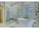 Bathroom showcasing a shower, bathtub, blue patterned wallpaper, and natural light from a large window at 418 W Carolina Ave, Summerville, SC 29483