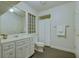Clean bathroom features white cabinets, a glass block window, and a shower with a white curtain at 418 W Carolina Ave, Summerville, SC 29483