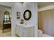 Bathroom with a white vanity and sink, complemented by a framed round mirror at 418 W Carolina Ave, Summerville, SC 29483