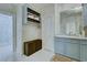 Bathroom with custom storage over the toilet, light blue vanity, and glass shower at 418 W Carolina Ave, Summerville, SC 29483