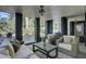 Relaxing covered patio features stone floors, comfortable seating, and views of the lush backyard at 418 W Carolina Ave, Summerville, SC 29483