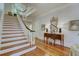 Elegant entryway with hardwood floors, staircase, and console table with lamps at 418 W Carolina Ave, Summerville, SC 29483