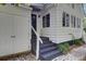 Charming white home featuring black stairs, adjacent garage door and brick foundation at 418 W Carolina Ave, Summerville, SC 29483