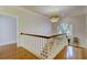 Hallway with hardwood floors, white railings, and arched windows providing natural light at 418 W Carolina Ave, Summerville, SC 29483