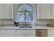 Kitchen sink with marble countertops, window and white cabinets at 418 W Carolina Ave, Summerville, SC 29483