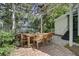 Inviting outdoor patio with pergola, brick pavers, and a dining table surrounded by lush greenery at 418 W Carolina Ave, Summerville, SC 29483
