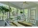 Relaxing screened porch with a swing, ceiling fan, outdoor furniture, and views of the landscaped yard at 418 W Carolina Ave, Summerville, SC 29483