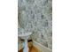 Charming powder room with patterned wallpaper, elegant pedestal sink, and gold-trimmed mirror at 418 W Carolina Ave, Summerville, SC 29483