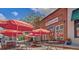 Outdoor restaurant featuring tables with umbrellas and chairs in a charming urban setting with red brick walls at 418 W Carolina Ave, Summerville, SC 29483