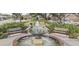 Charming park featuring a decorative water fountain, manicured greenery, benches, and walkways at 418 W Carolina Ave, Summerville, SC 29483