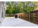 Backyard concrete patio features a black grill and a wood fence surrounding the perimeter at 5022 W Liberty Meadows Dr, Summerville, SC 29485