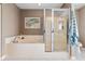 Well-lit bathroom with large bathtub, glass shower, and decorative art at 5022 W Liberty Meadows Dr, Summerville, SC 29485