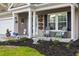 Inviting front porch with green Adirondack chairs and flower-filled hanging baskets welcomes you home at 5022 W Liberty Meadows Dr, Summerville, SC 29485