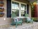 Charming front porch features two green Adirondack chairs and cheerful accent pillows at 5022 W Liberty Meadows Dr, Summerville, SC 29485