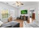 Bright living room featuring hardwood floors, a ceiling fan, and a view of the exterior through large windows at 5022 W Liberty Meadows Dr, Summerville, SC 29485