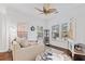 Bright living room with fan, beige sofa, hardwood floors, and windows letting in natural light at 5022 W Liberty Meadows Dr, Summerville, SC 29485