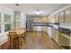 Bright kitchen features wood-look floors, stainless steel appliances, and a dining table at 527 Hainsworth Dr, Charleston, SC 29414