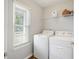 Bright laundry area equipped with washer, dryer, storage shelves, and natural light at 527 Hainsworth Dr, Charleston, SC 29414