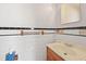 This bathroom features white tile, black trim, a wood towel rack and a sink with wood cabinets at 5321 Trudy St, North Charleston, SC 29418