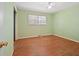A bedroom with green walls, wood floors and a window letting in natural light at 5321 Trudy St, North Charleston, SC 29418