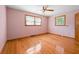 Bedroom with hardwood floors and pink walls featuring a ceiling fan and windows offering natural light at 5321 Trudy St, North Charleston, SC 29418