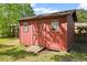 A charming red storage shed featuring wooden construction and a double door entrance at 5321 Trudy St, North Charleston, SC 29418