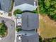 Aerial view of modern townhomes with rooftop decks featuring patio furniture and a blue jacuzzi overlooking wooded area at 539 Cooper Village Ln, Mount Pleasant, SC 29464