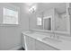 Well-lit bathroom with double sinks, white countertops, and a large mirror reflecting natural light at 539 Cooper Village Ln, Mount Pleasant, SC 29464