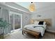 Bright bedroom with a light fixture, bench, and sliding glass doors leading to the outside at 539 Cooper Village Ln, Mount Pleasant, SC 29464