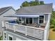 A spacious outdoor deck with seating area, dining table, and retractable awning for shade and comfort at 539 Cooper Village Ln, Mount Pleasant, SC 29464