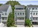 Three-story townhouse featuring a light blue exterior, balconies, white railings and a paved driveway leading to a garage at 539 Cooper Village Ln, Mount Pleasant, SC 29464