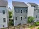 Rear exterior view of a three-story townhome featuring fenced yard and neutral-colored siding and trim at 539 Cooper Village Ln, Mount Pleasant, SC 29464
