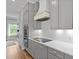 Bright kitchen with grey cabinetry, stainless appliances, and an electric cooktop with a modern range hood at 539 Cooper Village Ln, Mount Pleasant, SC 29464