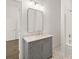 Bathroom with gray vanity, white marble counter, modern mirror and fixtures at 55 Maple St, Charleston, SC 29403