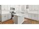 Modern kitchen featuring white cabinetry, stainless steel appliances, and a center island with sink at 55 Maple St, Charleston, SC 29403