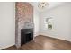 Bright room featuring hardwood floors, a brick fireplace, modern light fixture and neutral walls at 55 Maple St, Charleston, SC 29403