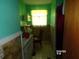 Compact bathroom featuring a tiled floor, toilet, sink, and overhead lighting at 604 King St, Walterboro, SC 29488