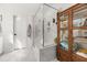 Bright bathroom showcasing a frameless glass shower, white marble tiling, and a decorative display cabinet at 619 Trio Ln, Summerville, SC 29486