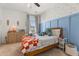 Cozy bedroom with blue accent wall, patterned wallpaper, and a wooden bed frame at 619 Trio Ln, Summerville, SC 29486