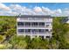 Expansive aerial view of a stately home with multiple balconies surrounded by tropical foliage at 67 Lost Village Trl # 4, Edisto Island, SC 29438