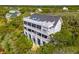 Stunning aerial view of a multi-level home with a rooftop deck nestled amongst lush greenery at 67 Lost Village Trl # 4, Edisto Island, SC 29438