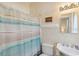 Cozy bathroom with a shower featuring a patterned curtain, a toilet, and a vanity sink at 67 Lost Village Trl # 4, Edisto Island, SC 29438