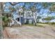 Charming beach house with a light-colored exterior, tall staircase, and lovely mature trees at 67 Lost Village Trl # 4, Edisto Island, SC 29438